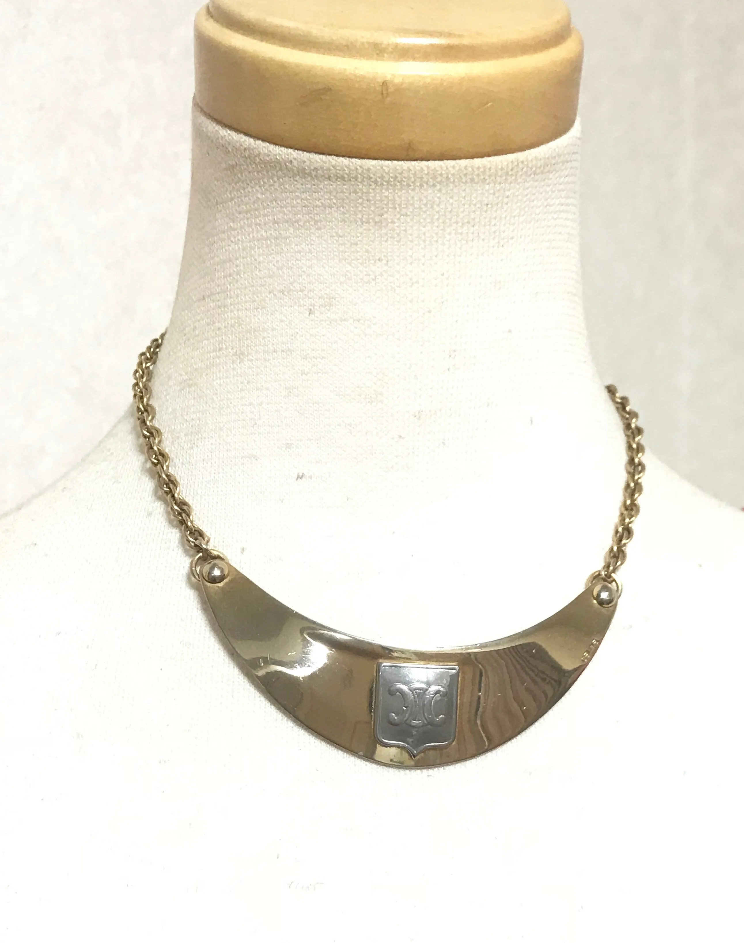 Vintage Celine gold tone crescent moon shape necklace with silver triomphe logo. 05062810