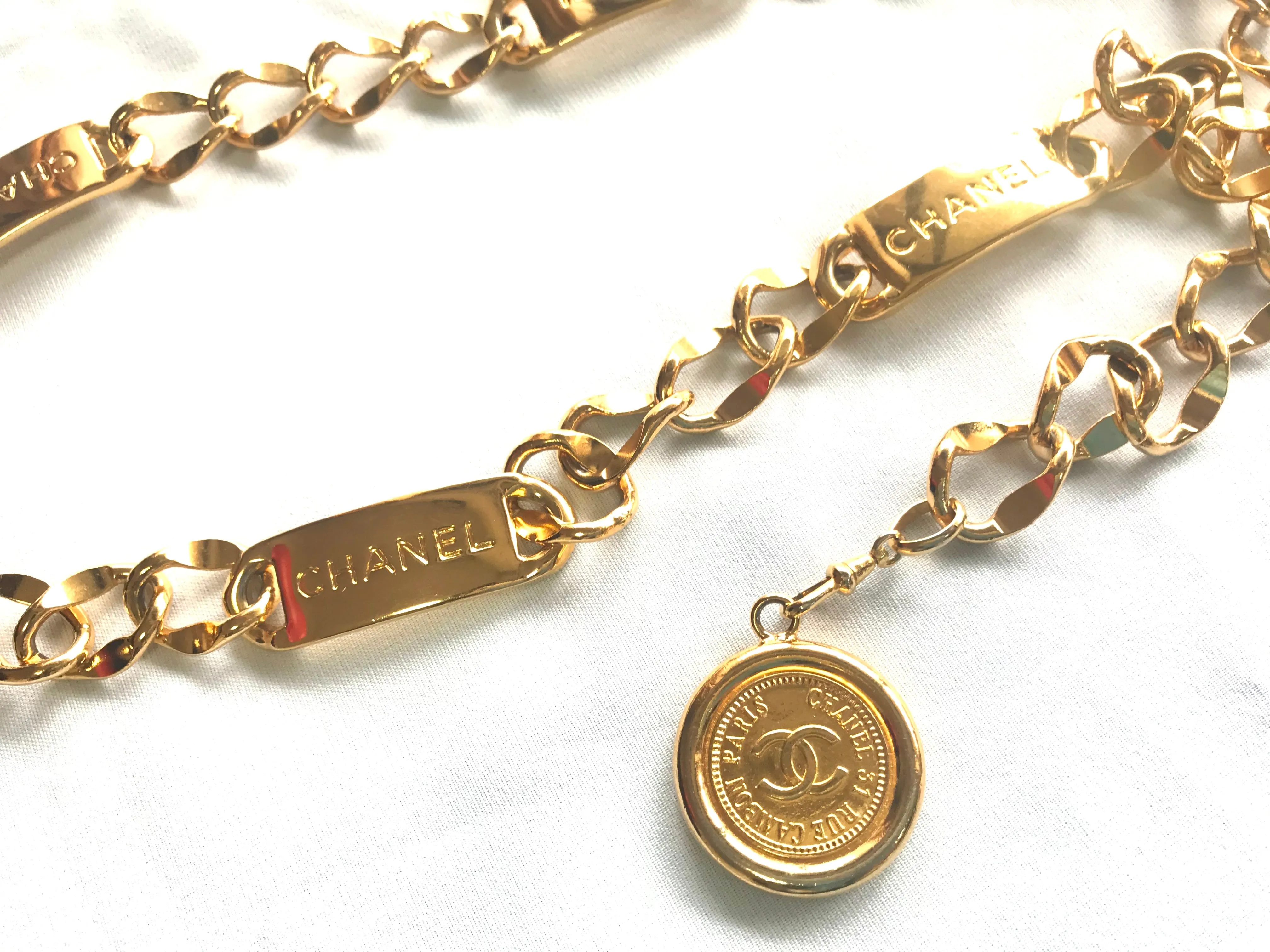 Vintage CHANEL golden thick chain belt with logo engraved bar motifs and a round charm to the end. Must have gorgeous accessory.