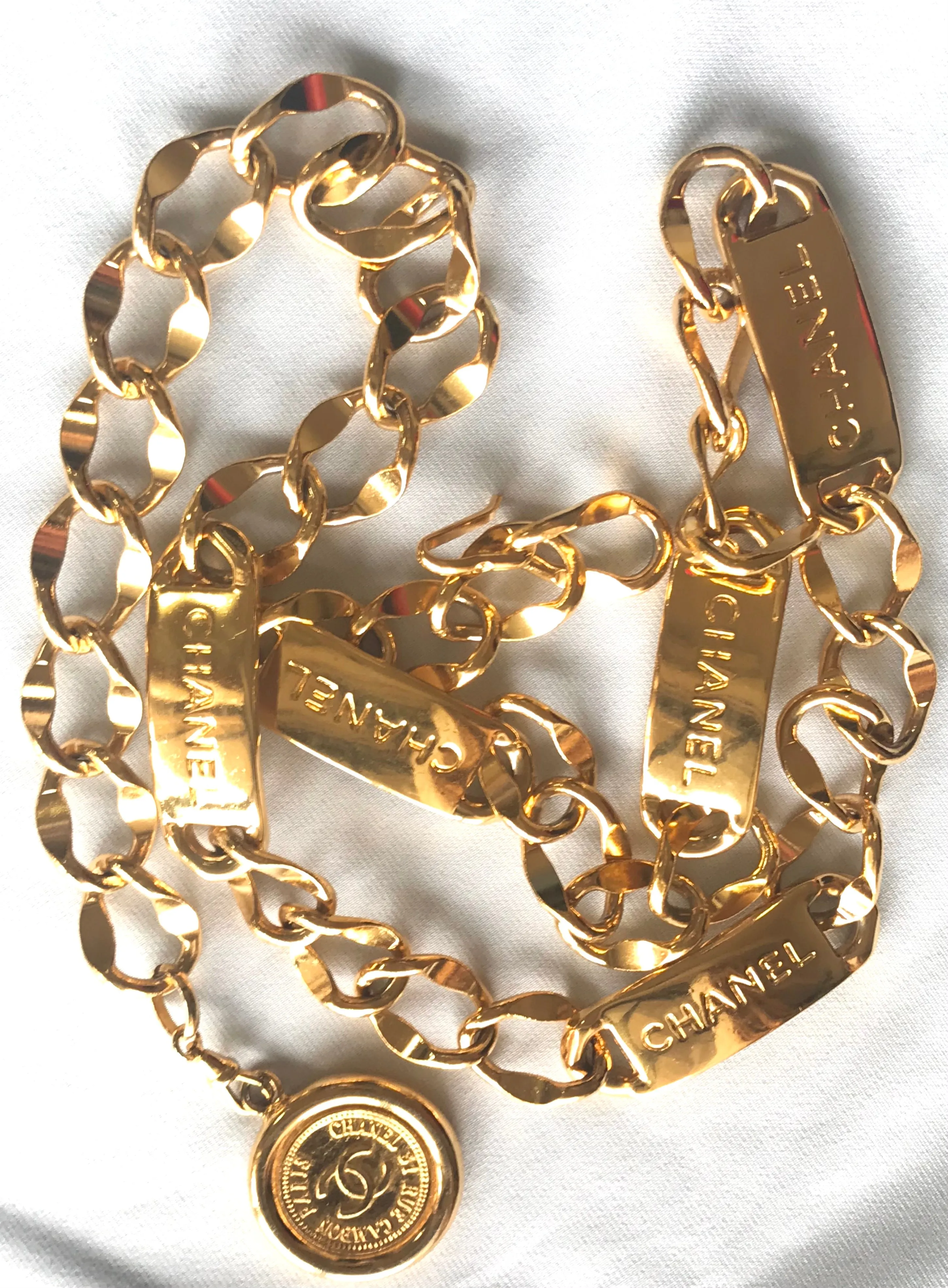 Vintage CHANEL golden thick chain belt with logo engraved bar motifs and a round charm to the end. Must have gorgeous accessory.