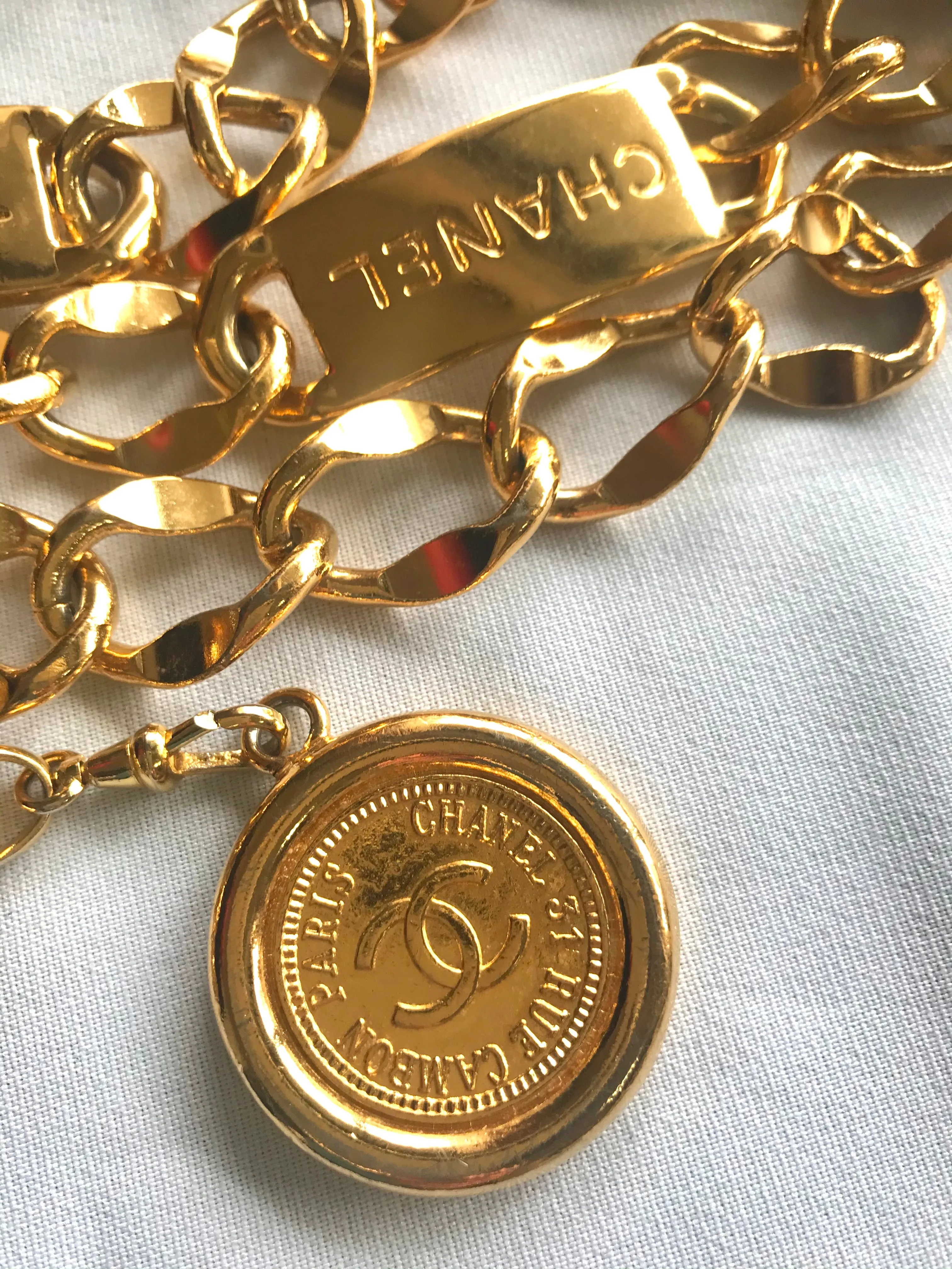 Vintage CHANEL golden thick chain belt with logo engraved bar motifs and a round charm to the end. Must have gorgeous accessory.